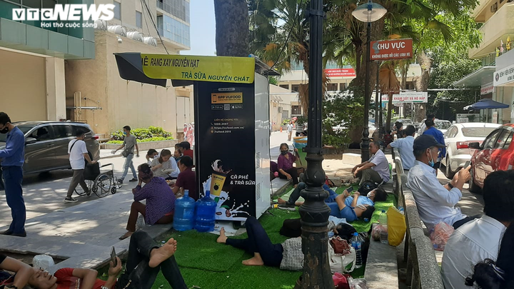 Người nhà bệnh nhân ăn cơm dưới chân tòa nhà, ngủ ở gốc cây trốn nắng nóng - 8