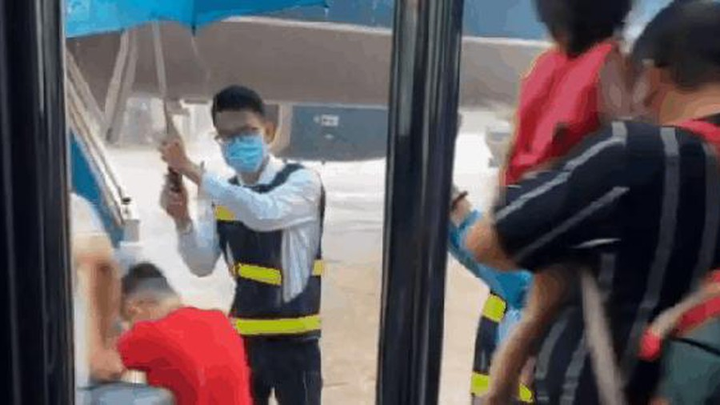 Dầm mình dưới mưa che ô cho khách, 2 tiếp viên hàng không nhận 'bão like' - 1