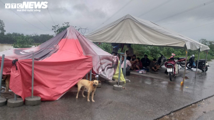 Mưa lớn kéo dài, dân Quảng Trị dựng lều bạt bên đường tránh lũ - 1