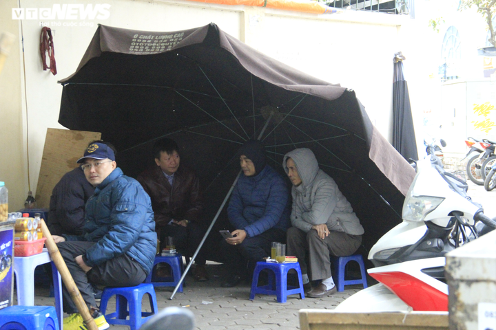 Ảnh: Người Hà Nội đi ủng, mặc áo mưa chống chọi cái rét sâu nhất đầu mùa - 10