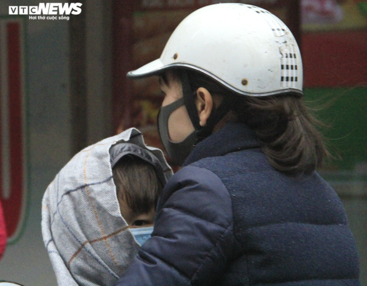 Ảnh: Người Hà Nội đi ủng, mặc áo mưa chống chọi cái rét sâu nhất đầu mùa - 14