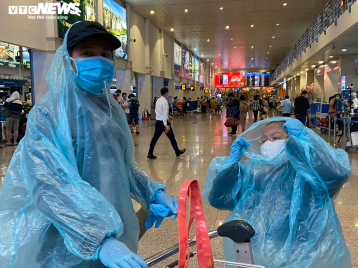 29 Tết, sân bay Tân Sơn Nhất thưa thớt, hành khách kín mít đồ bảo hộ - 6