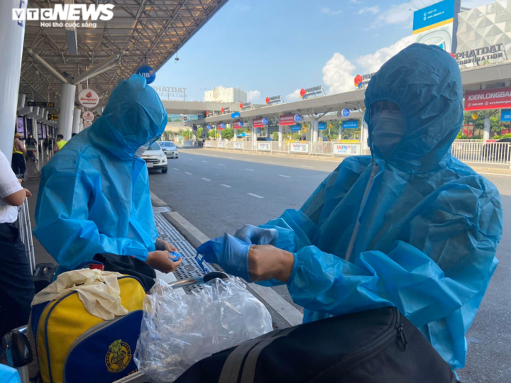 29 Tết, sân bay Tân Sơn Nhất thưa thớt, hành khách kín mít đồ bảo hộ - 2