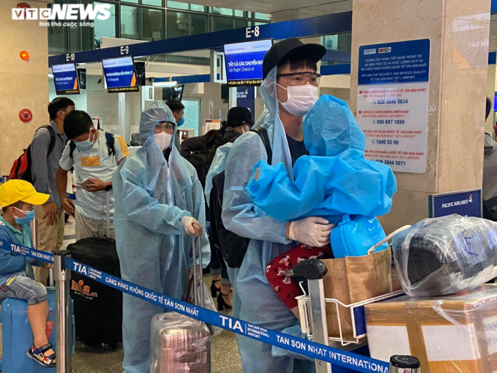 29 Tết, sân bay Tân Sơn Nhất thưa thớt, hành khách kín mít đồ bảo hộ - 11