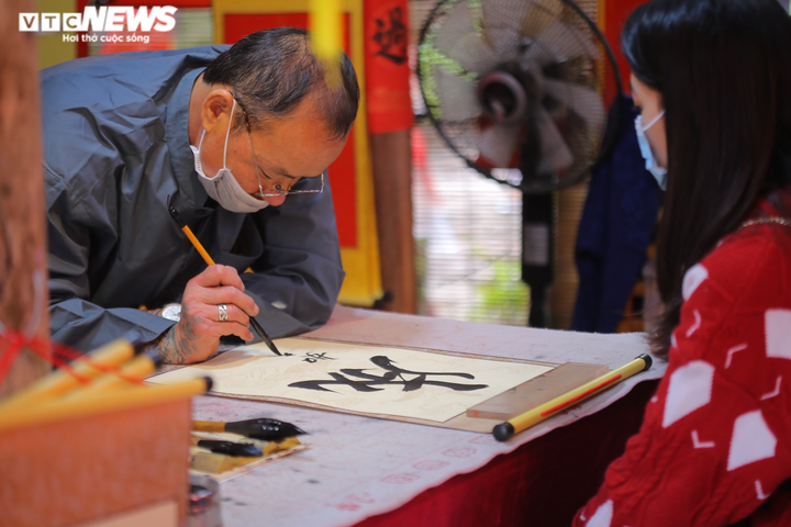 Ảnh: Ông đồ cho chữ qua tấm chắn tại Văn Miếu ngày mùng 2 Tết - 8