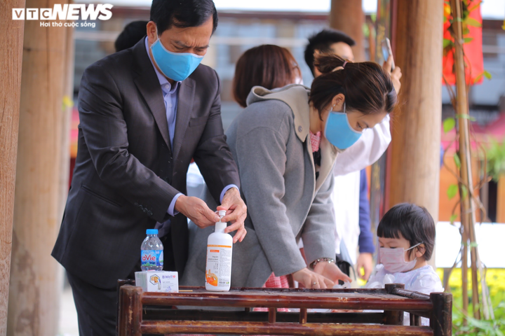 Ảnh: Ông đồ cho chữ qua tấm chắn tại Văn Miếu ngày mùng 2 Tết - 2