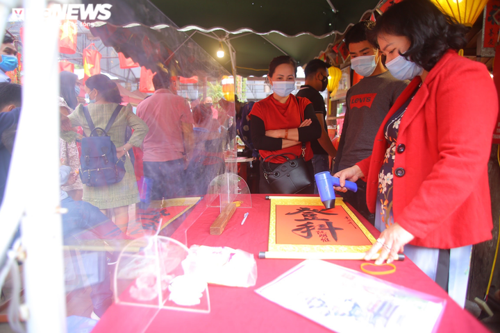 Ảnh: Ông đồ cho chữ qua tấm chắn tại Văn Miếu ngày mùng 2 Tết - 3