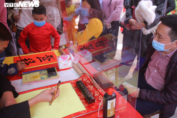 Ảnh: Ông đồ cho chữ qua tấm chắn tại Văn Miếu ngày mùng 2 Tết - 4