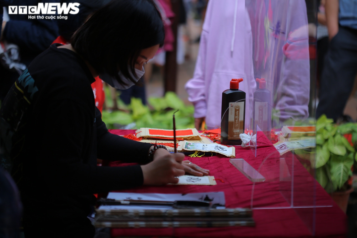 Ảnh: Ông đồ cho chữ qua tấm chắn tại Văn Miếu ngày mùng 2 Tết - 7