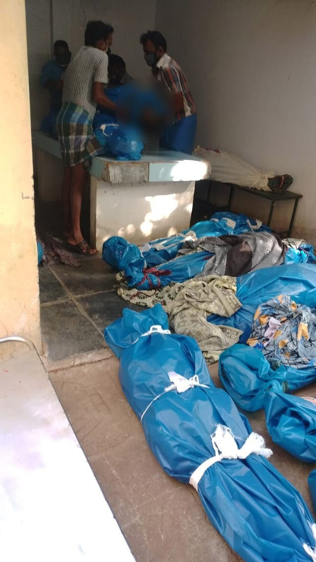 Gia đình bệnh nhân COVID-19 ở Ấn Độ tìm xác người nhà giữa đống thi thể - 1