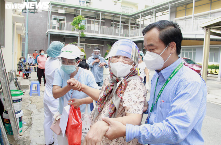 Người già mắc bệnh nền ở TP.HCM ngồi xe lăn, chống gậy đi tiêm vaccine COVID-19 - 5