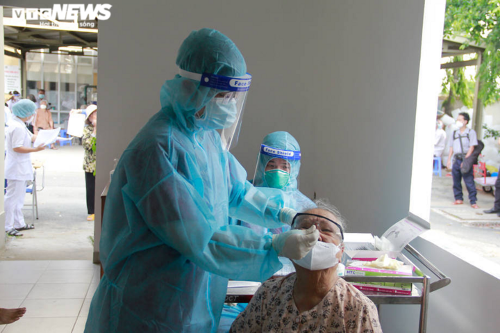 Người già mắc bệnh nền ở TP.HCM ngồi xe lăn, chống gậy đi tiêm vaccine COVID-19 - 7