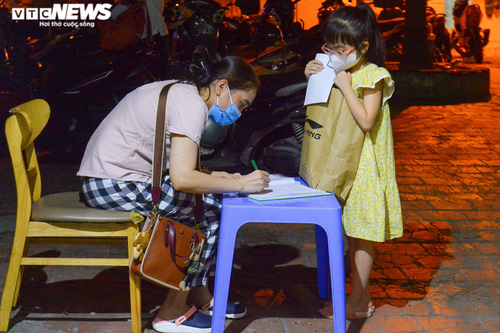 Ảnh: Người Hà Nội xếp hàng dài xin xác nhận giấy đi đường đến tối muộn - 10