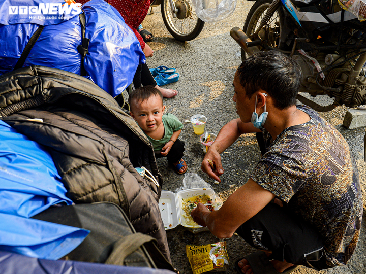 Ảnh: 500 người hồi hương ngồi bên lề đường Hà Nội ăn vội suất cơm tiếp tế - 10