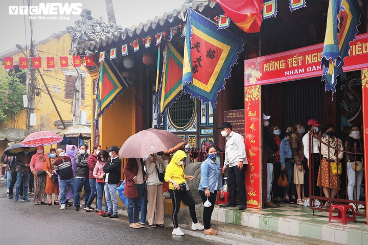 Ảnh: Người dân đội mưa xếp hàng chờ vía chùa Ông ở phố cổ Hội An - 1
