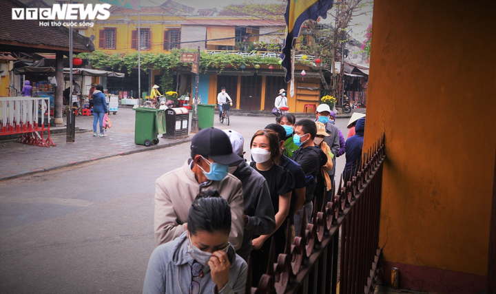 Ảnh: Người dân đội mưa xếp hàng chờ vía chùa Ông ở phố cổ Hội An - 2