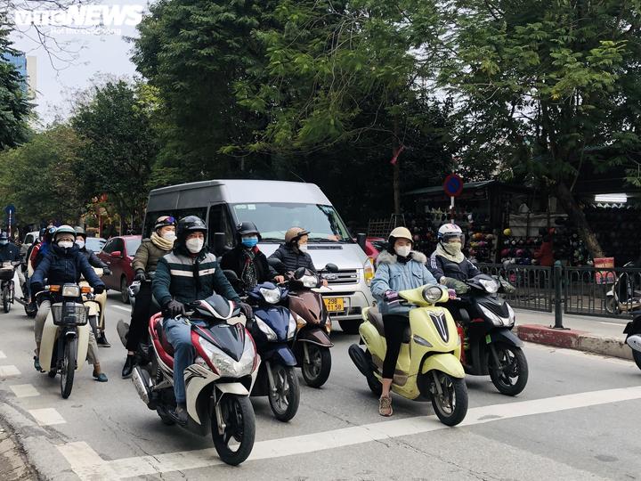 Ảnh: Trời tạnh ráo, người Hà Nội vẫn mặc áo mưa tránh cái rét thấu xương - 2