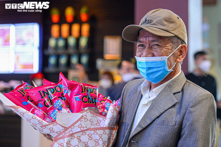Ông Bùi Thư Sinh ở Phan Huy Chú, Nam Định mang theo bó hoa đặc biệt được làm từ những gói bim bim để tặng 3 cháu nội.