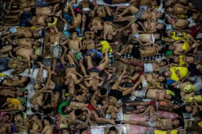 Tù nhân nằm chen nhau, chật kín cả sân bóng rổ.