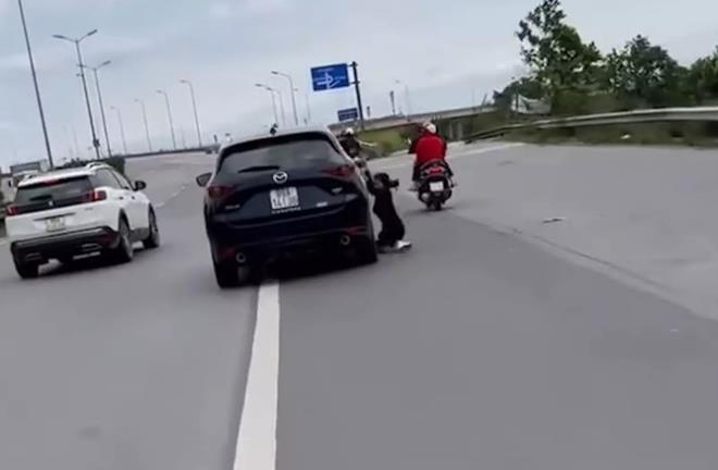 Người phụ nữ đu bám cánh cửa ô tô đang chạy - 1