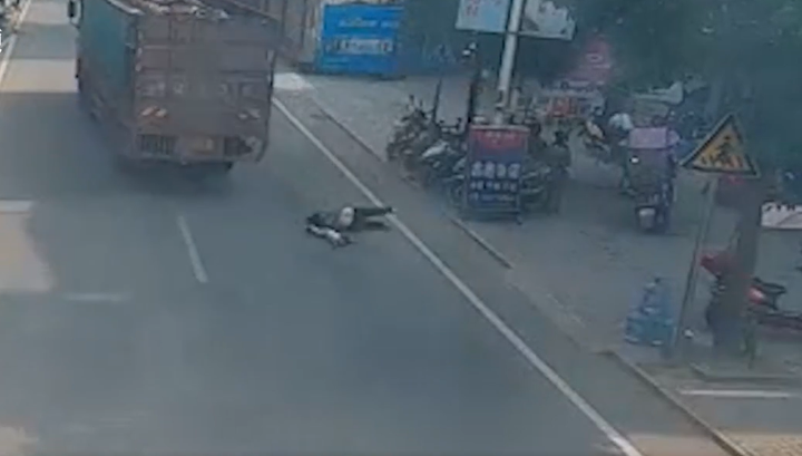 Lao ra cứu bé trai trước đầu xe tải, người phụ nữ bị cắt cụt mất một tay - 2