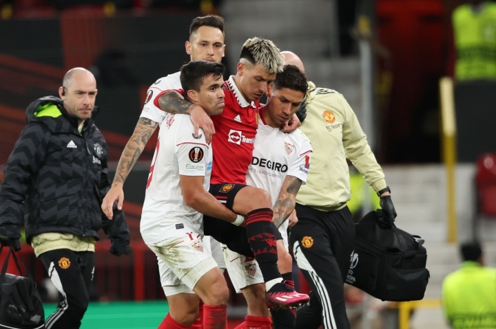 Hậu vệ Man Utd chấn thương nặng, được 2 cầu thủ Sevilla bế ra khỏi sân - 1
