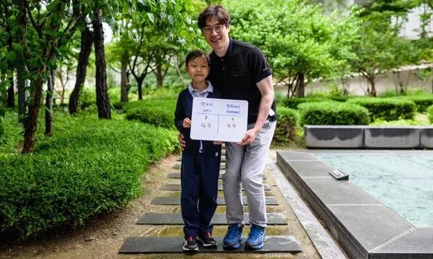 Bé Yoon Jae-ha (trái), cầm tấm bảng ghi tuổi quốc tế là 8 và tuổi Hàn Quốc là 9. Ảnh: AFP