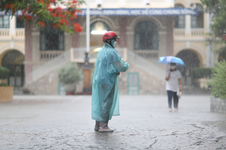 Mưa lớn, đợi lâu nên một số phụ huynh di chuyển vào phía trong để tìm con. (Ảnh: L.H)