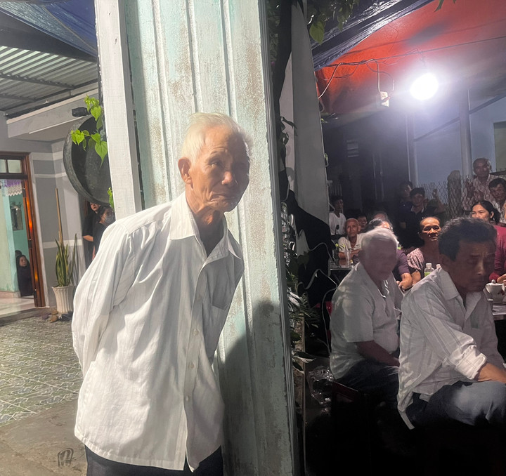 Cụ Dở ra cổng đợi con trai và con dâu về nhà.