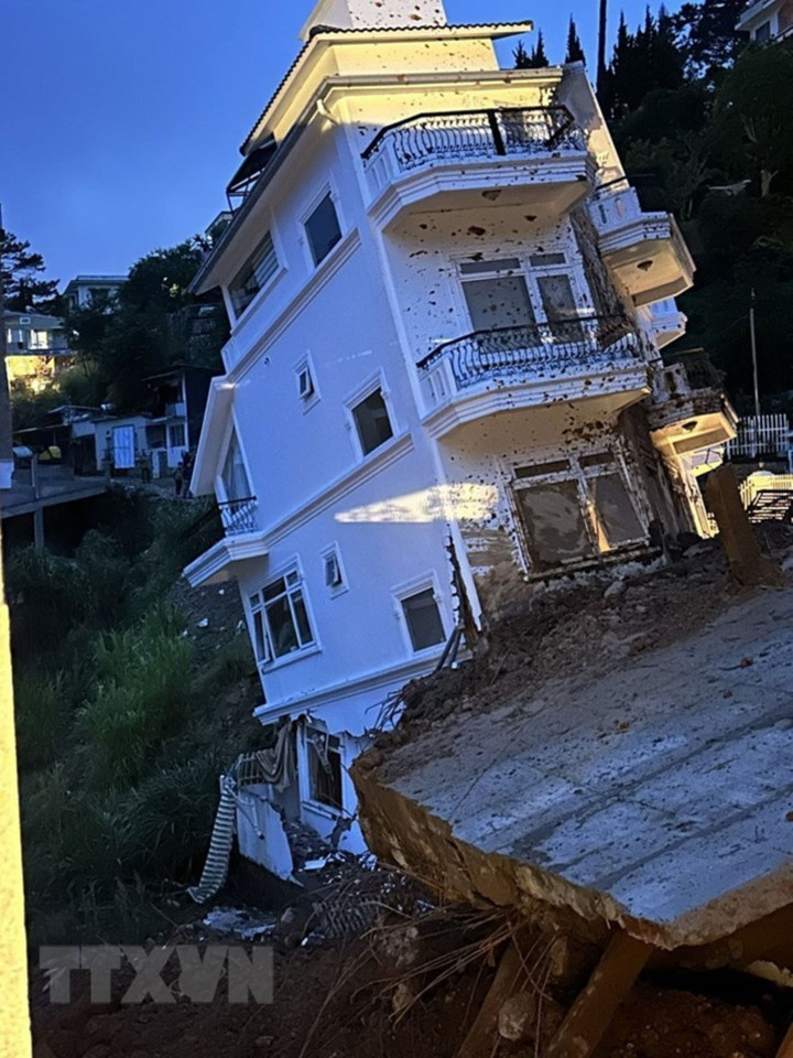 Một căn nhà cao tầng bị đổ nghiêng. (Ảnh: Chu Quốc Hùng/TTXVN)