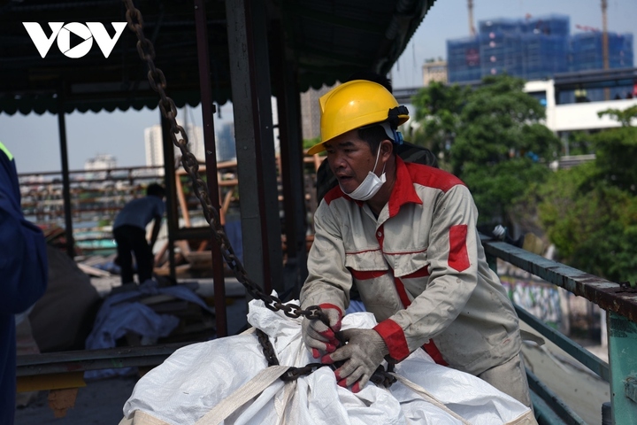 Phế thải được chuyển bằng cẩu xuống ô tô để chuyển đi.