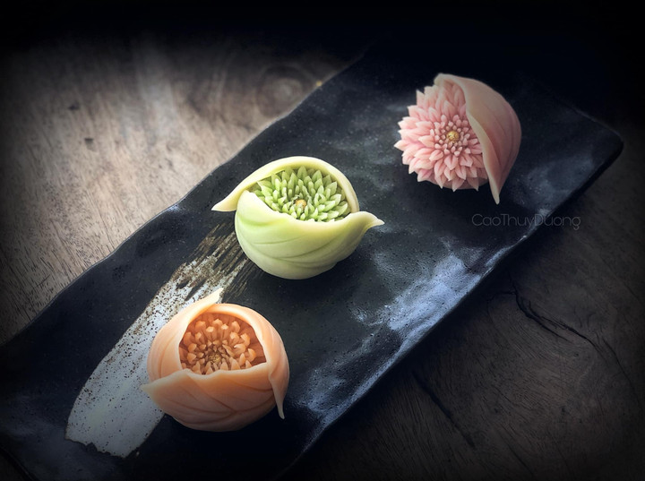 Mấy đoá cúc thược dược e ấp trong những chiếc lá.