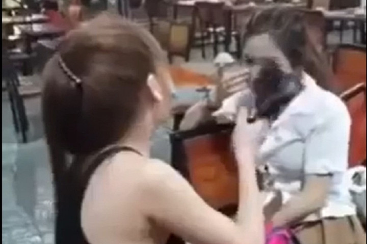 Thiếu nữ 16 tuổi (áo trắng) bị vợ của chủ quán hành hung - Ảnh cắt từ clip