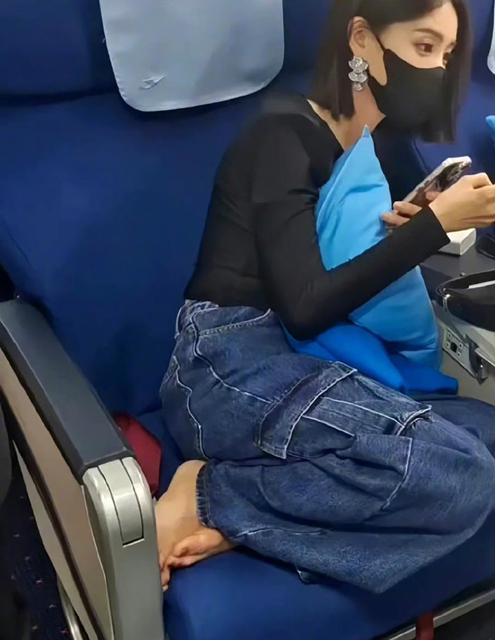 Hình ảnh Lý Nhất Đồng để chân lên ghế máy bay.