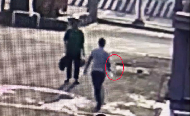 Hiền cầm chai xăng tưới vào người bà M. (Ảnh cắt từ video)