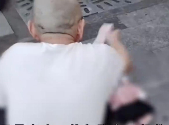 Người đàn ông cầm từng tờ tiền 100 nhân dân tệ tung ra đường, mời mọi người lấy.