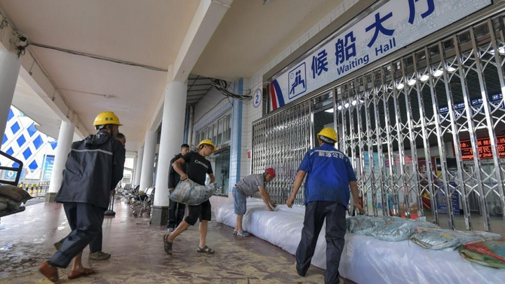 Ngày 16/7, công nhân đặt bao cát chặn lũ ở lối vào sảnh chờ của cảng Tú Anh ở thành phố Hải Khẩu, tỉnh Hải Nam. (Ảnh: VCG)