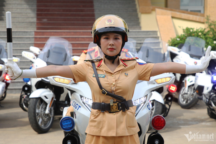 Đại úy Cao Hồng Nhung cùng đồng nghiệp thực hiện lại các động tác chỉ huy giao thông.