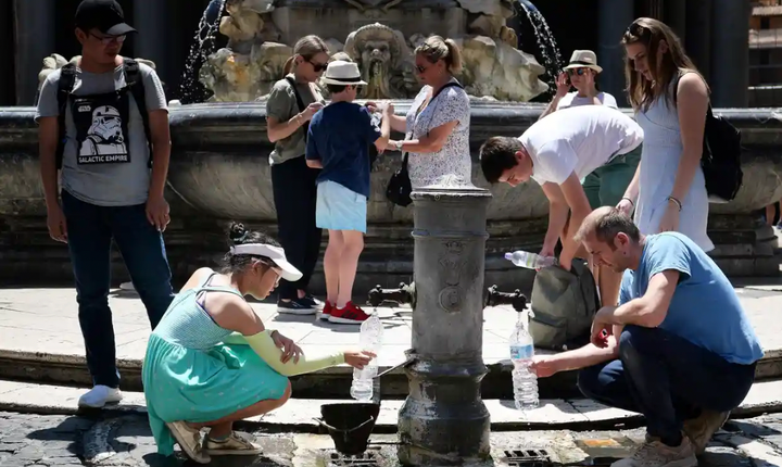 Khách du lịch ở Rome uống nước từ đài phun nước công cộng trong đợt nắng nóng bất thường. (Ảnh: Getty)