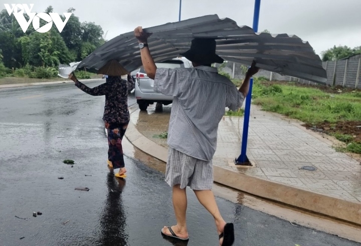 Người dân thu gom lại những mái tôn bị lốc cuốn bay.