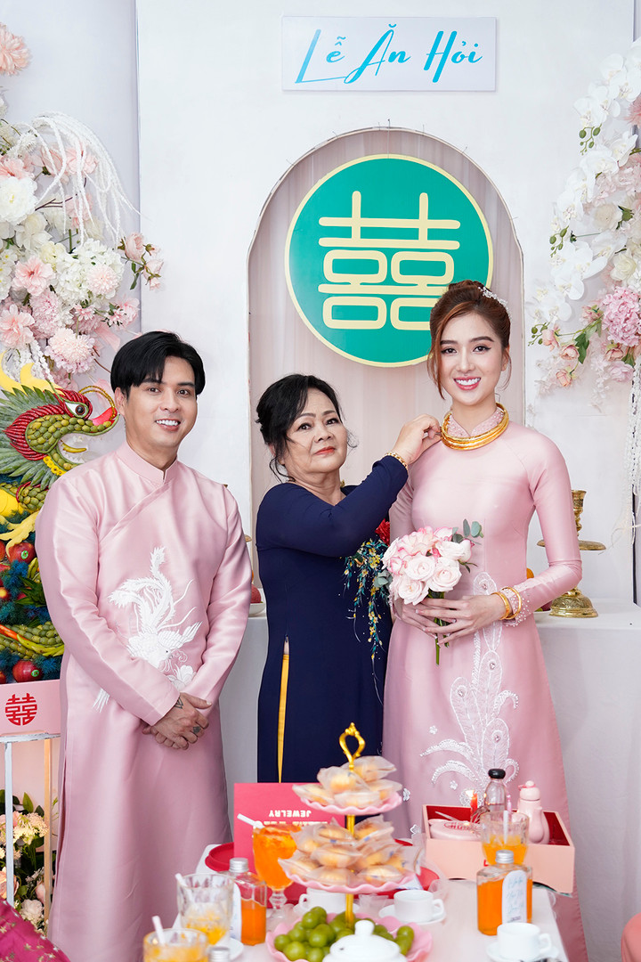 Cô dâu, chú rể diện áo dài cùng tông màu hồng được thiết kế riêng. Đại diện gia đình hai bên thực hiện các nghi lễ trao quà truyền thống.