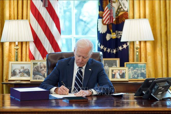Tổng thống Mỹ Joe Biden ký một sắc lệnh tại Nhà Trắng ngày 11/3/2021. (Ảnh: AFP/TTXVN)