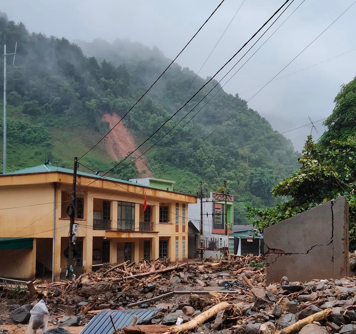 Trường Hồ Bốn nằm ở taluy âm của đường Quốc lộ 32 nên lũ quét qua để lại lượng đất đá khổng lồ trong khuôn viên. Chia sẻ với Tiền Phong, thầy Nguyễn Xuân Trường, hiệu trưởng cho biết, sau trận lũ, 17 căn nhà của giáo viên bị thiệt hại nghiêm trọng, 4 căn nhà sập hoàn toàn. Cổng trường, nhà thư viện, nhà kho cũng bị đổ sập. Phòng tin học với 25 bộ máy tính bên trong nguy cơ hư hỏng do bùn đất tràn vào. Khoảng 5 tấn xi măng và nhiều sắt thép đã tập kết phục vụ cho việc tu sửa đã bị lũ cuốn trôi. (Ảnh: Giáo dục thời đại)