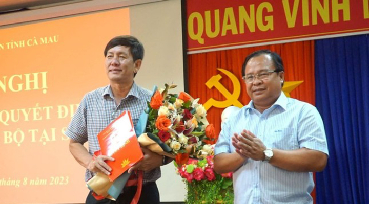Ông Nguyễn Minh Luân, Phó Chủ tịch UBND tỉnh Cà Mau trao quyết định và tặng hoa chúc mừng ông Dư Minh Hùng (bên trái). (Ảnh: Báo Cà Mau).