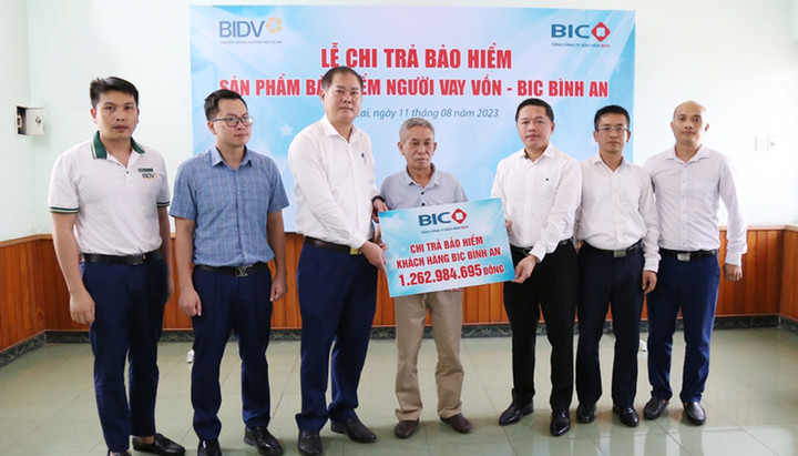Đại diện lãnh đạo BIC và BIDV Lào Cai trao tiền bồi thường cho thân nhân khách hàng.