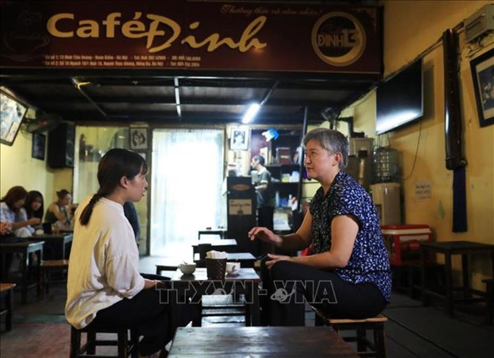 Bộ trưởng Bộ Ngoại giao Australia Penny Wong nghe đầu bếp Sam Trần giới thiệu về cà phê trên phố cổ Hà Nội.