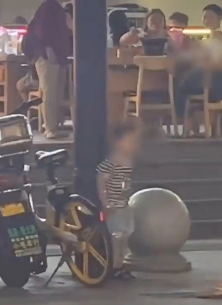 Cậu bé bất lực khi bị trói vào cột.