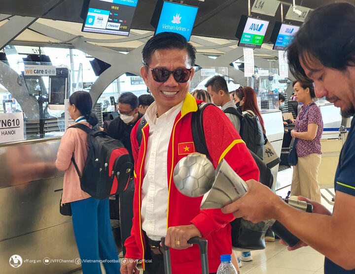 Niềm vui của HLV Hoàng Anh Tuấn khi cùng học trò mang cúp vô địch về nước.