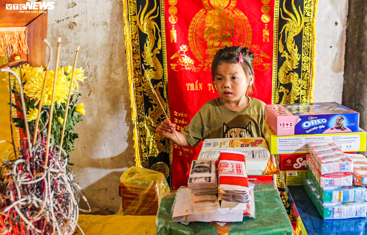 Bé Khánh Vy thắp hương trên bàn thờ mẹ. (Ảnh: Trọng Tùng)