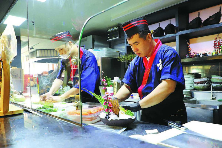 Đầu bếp tại một nhà hàng Nhật Bản ở Trung Quốc đang chuẩn bị đồ ăn cho khách. (Ảnh: China Daily)
